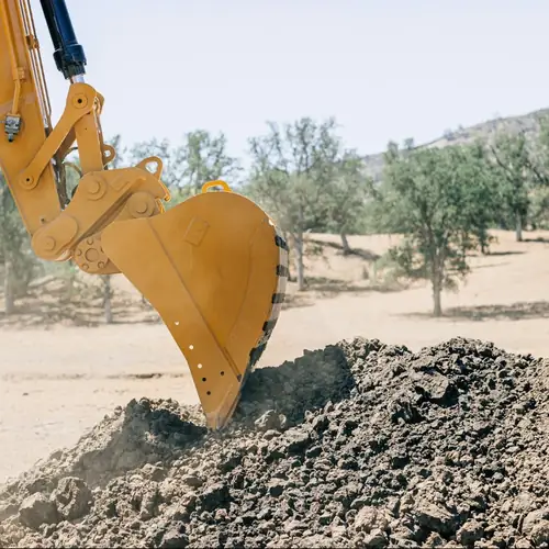 Excavator bucket moving soil
